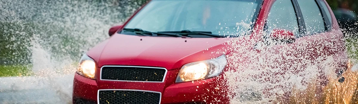Conductor manteniendo el control del volante bajo lluvia intensa.