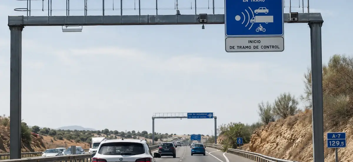 Pórtico con cámaras y cartel de inicio de tramo de control sobre una autovía española, explicando cómo funciona el radar de tramo
